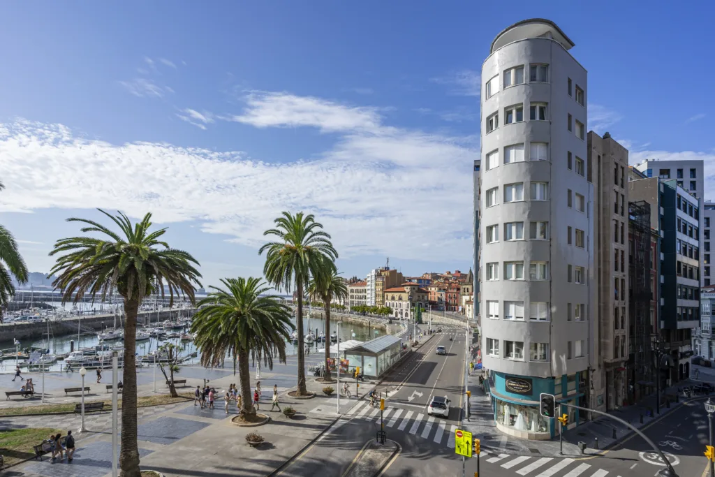 Puerto deportivo de Gijón, palmeras y edificios junto al paseo